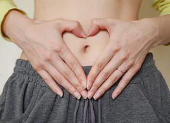 Midsection of woman touching heart shape