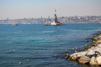 Scenic view of sea against buildings in city