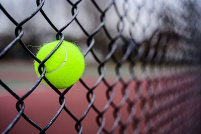 Tennis ball stuck in a fence