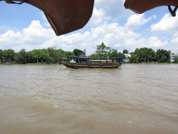 Boat in river against sky