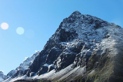 Low angle view of mountain against clear blue sky