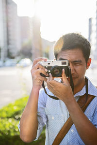 Mature man taking photo with classic range finder camera in kyoto