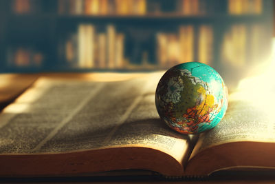 Close-up of globe on open book