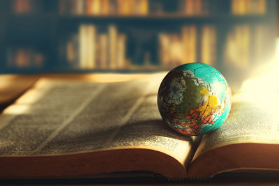 Close-up of globe on open book