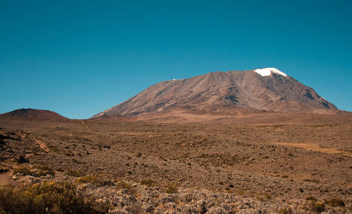 Scenic view of mountains against clear blue sky