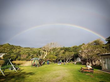 Scenic view of rainbow in park against sky