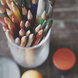 High angle view of colored pencils and paintbrushes in container