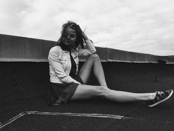 Portrait of young woman against sky