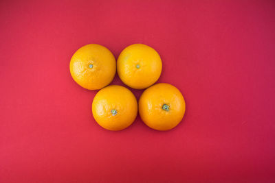 Close-up of orange fruit against red background