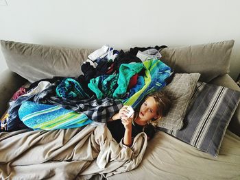 Portrait of young woman relaxing on sofa at home