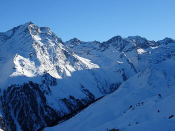 Scenic view of snow covered mountains against clear sky