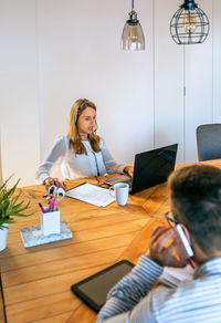 Young woman with headset working in customer help service of coworking