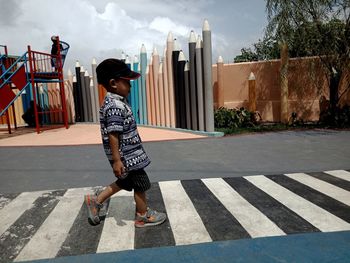 Full length of boy with arms raised in city