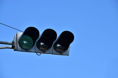 Low angle view of road signal against clear blue sky