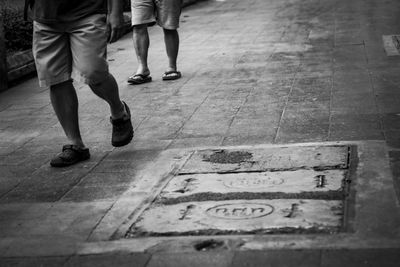 Low section of men walking on footpath