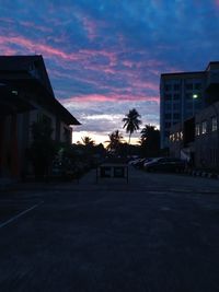 Silhouette buildings against sky at sunset