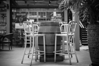 Empty chairs and tables at sidewalk cafe against building