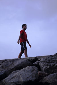 Low angle view of woman standing on rock
