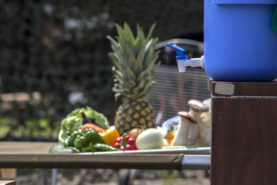 Water container by various fruits and vegetables on table