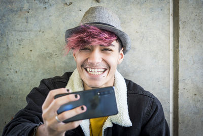 Portrait of smiling young man using mobile phone