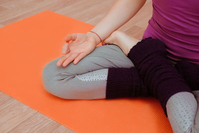 Low section of woman sitting on floor at home