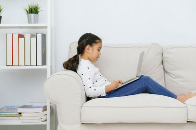 Woman sitting on sofa at home