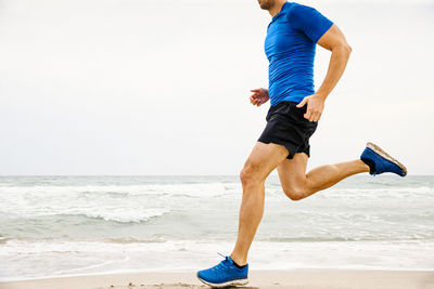 Full length of man on beach against clear sky