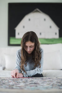 Portrait of woman looking down while sitting on table