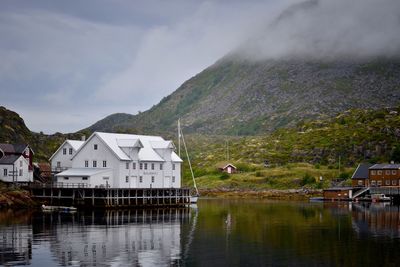 Buildings by lake against sky