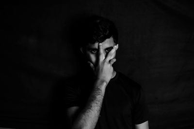 Portrait of young man against black background