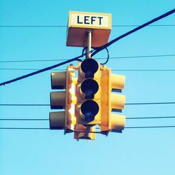 Low angle view of traffic light against blue sky