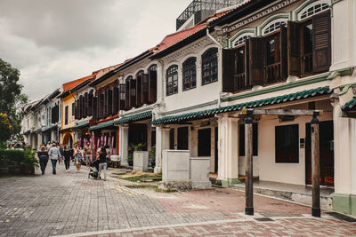 People on street by building against sky