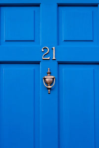 House number 21 on a blue wooden front door in london 