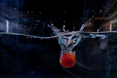 Close-up of strawberry over water against black background