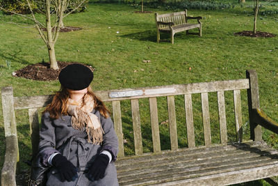 Woman sitting on bench in park
