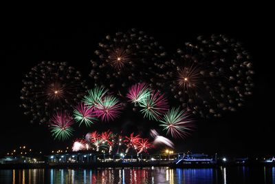 Firework display over river at night