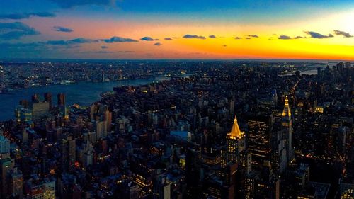 Aerial view of city lit up at sunset