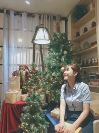 Woman in illuminated christmas tree