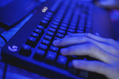 Cropped image of man using computer keyboard while playing game