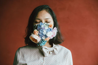 Close-up of woman with flowers on mask