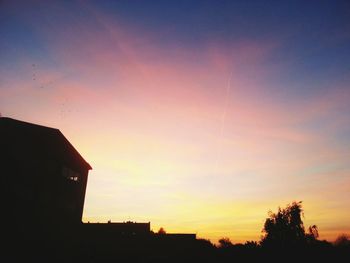 Low angle view of silhouette building against sky at sunset