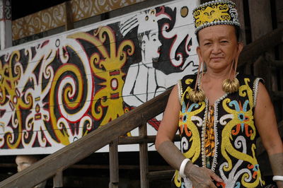 Portrait of woman standing by railing