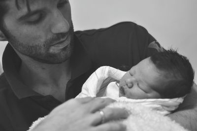 Close-up of father carrying baby boy at home