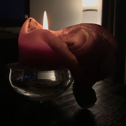 Close-up of hand holding lit candles on table