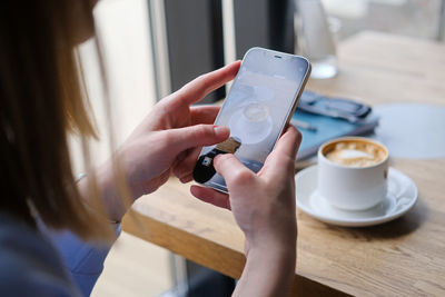 Close up of female hand's taking photo of coffee cup