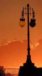 Low angle view of street light against orange sky