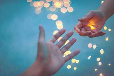 Close-up of hand holding illuminated lights