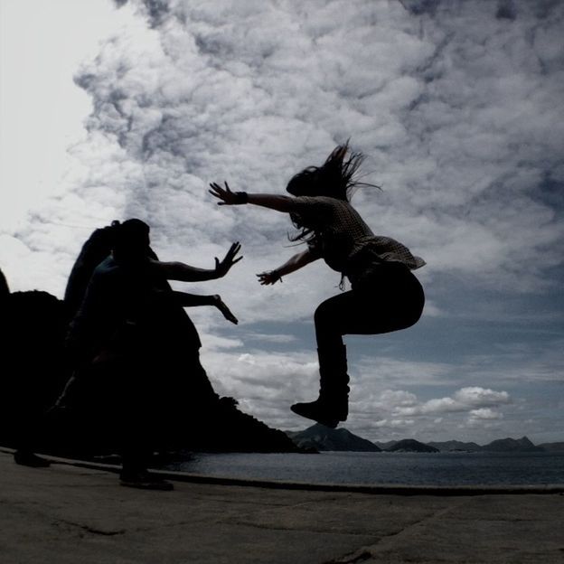 sky, cloud - sky, cloudy, silhouette, cloud, bird, mid-air, flying, statue, animal themes, water, sculpture, full length, low angle view, sea, one person, outdoors, nature, human representation, art and craft