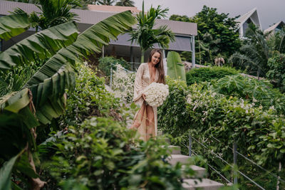 Young woman standing amidst plants