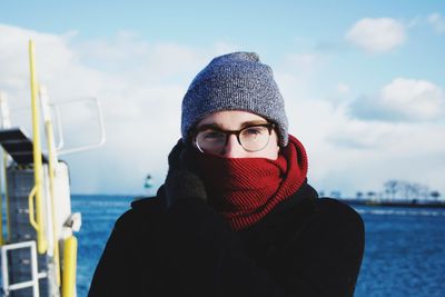 Close-up portrait of young woman standing against sky